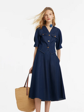 a lady in a v-neck denim top and half skirt with a rose choker